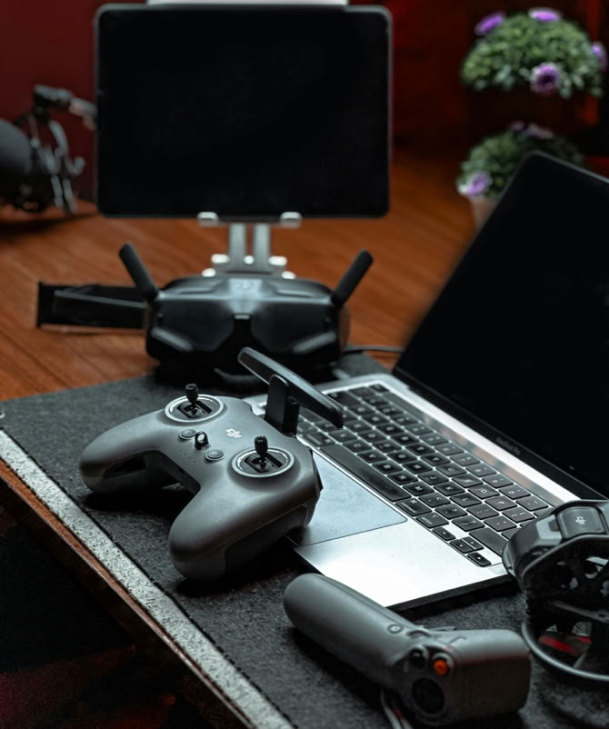 A sleek drone controller setup including a laptop and tablet in a modern office space.