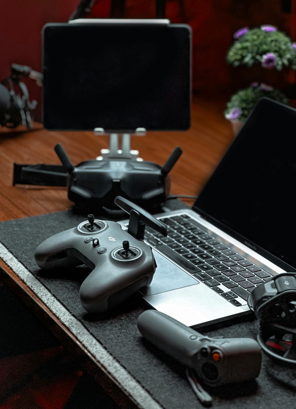 A sleek drone controller setup including a laptop and tablet in a modern office space.